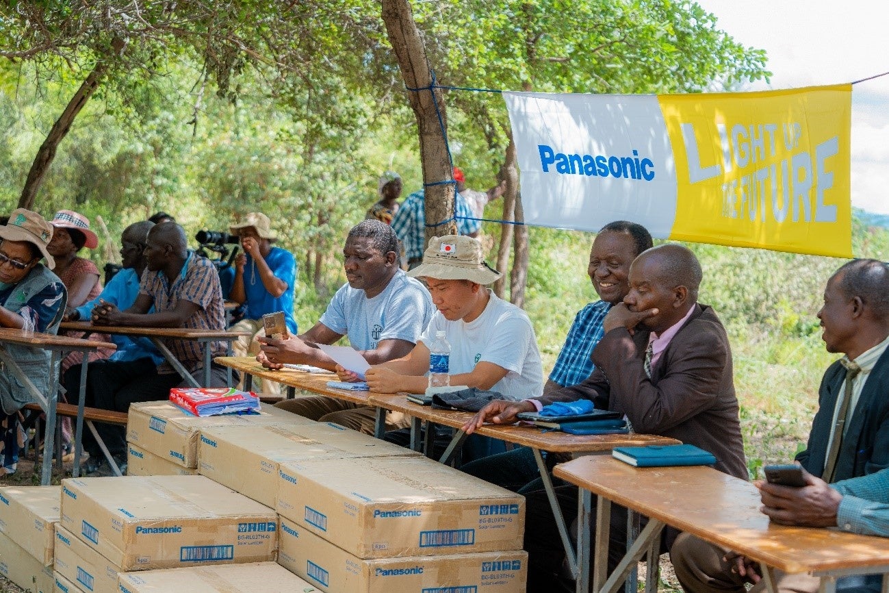 寄贈を受けたソーラーランタン（手前の箱）とADRA Japan現地駐在員 上田（中央）