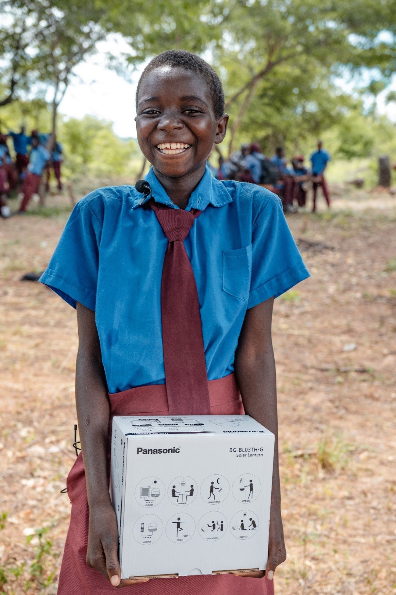太陽光ランタンを受け取り満面の笑みを浮かべています