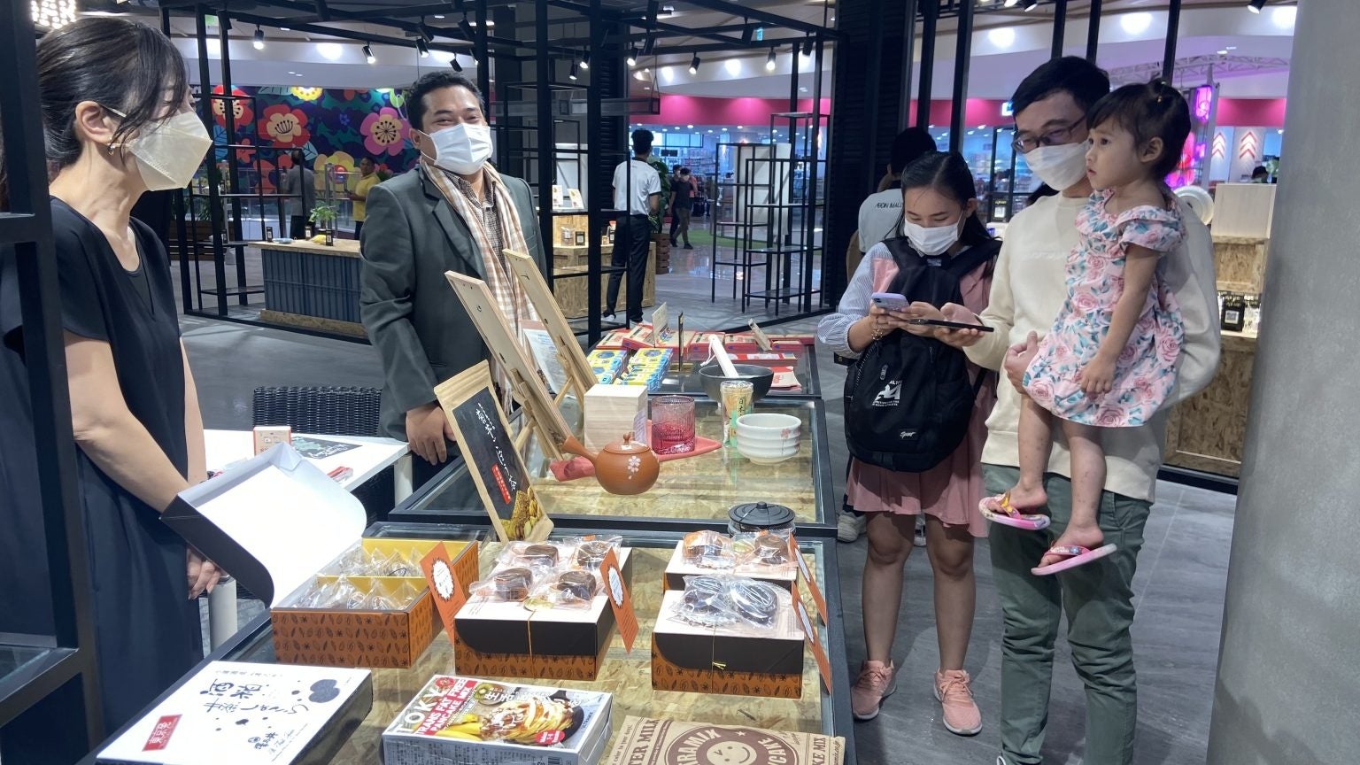 QRコードを読み取り、商品の詳細をご覧になるお客様。ECショールーム「AEON MALL PLUS」＠イオンモール ミエンチェイ（2022年12月15日、ジェイグラブ撮影）