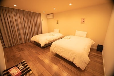 暖かい色合いのアフリカンモダンテイストのツインベッドルーム