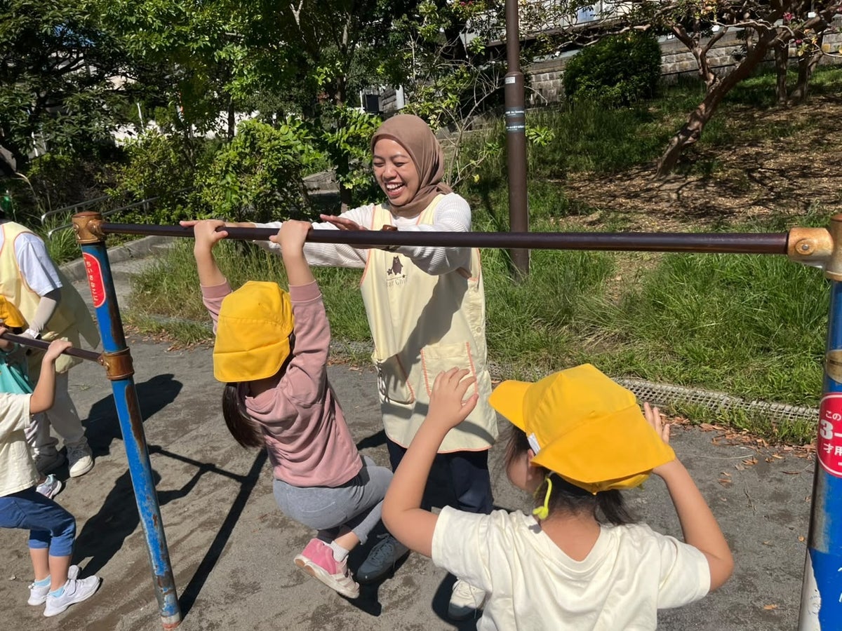 (左)散歩先の公園で園児と遊ぶ研修保育士
