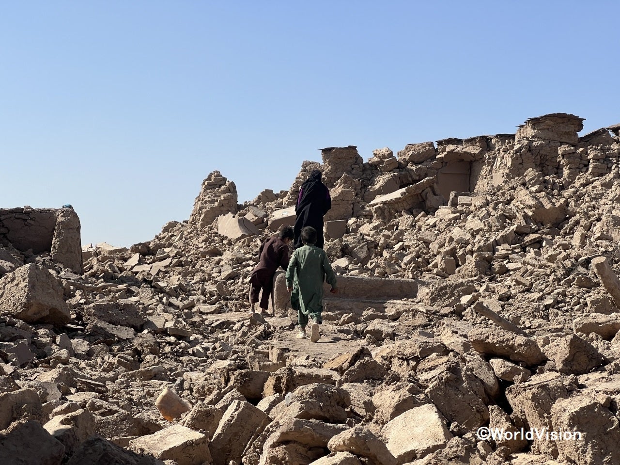 崩れた家から貴重品を取り出そうとする子どもたち