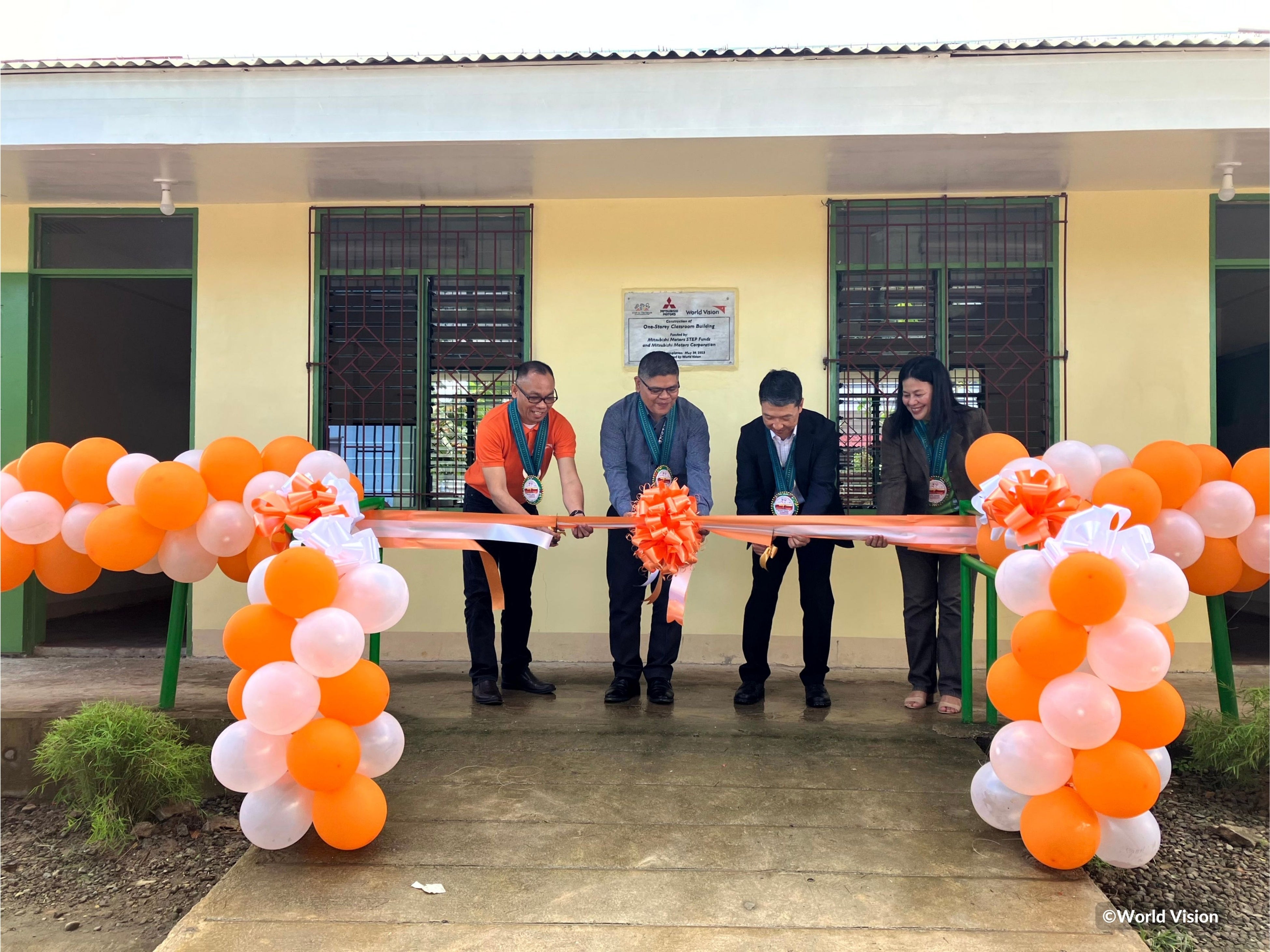 新校舎前でリボンカット（右からビオレッタ校長、宇佐美様、教育委員会ザルディ様、ワールド・ビジョンのボニファシオ スタッフ）