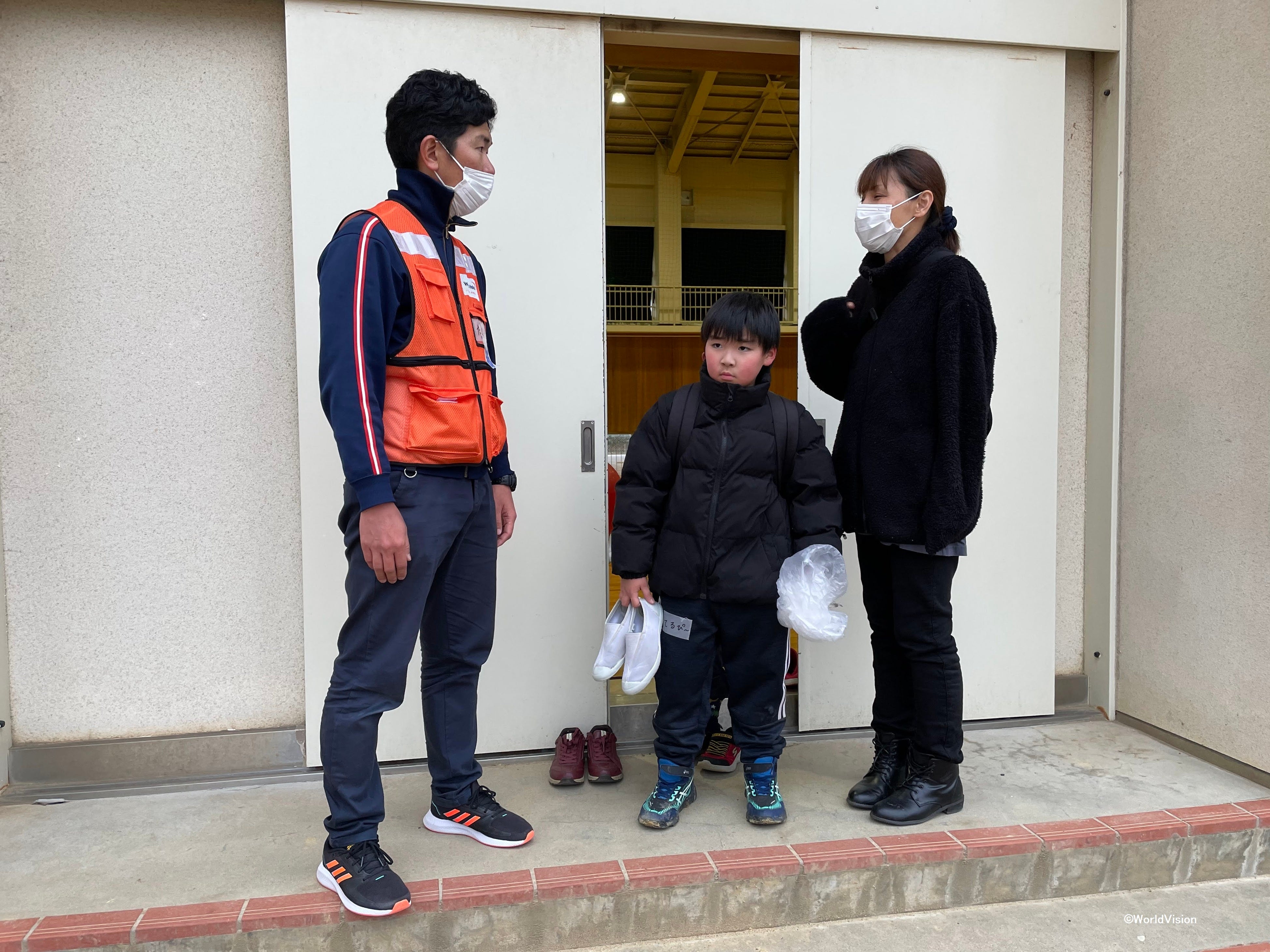 お迎えにいらした保護者の方と話すWVJ松岡スタッフ（3月7日撮影）