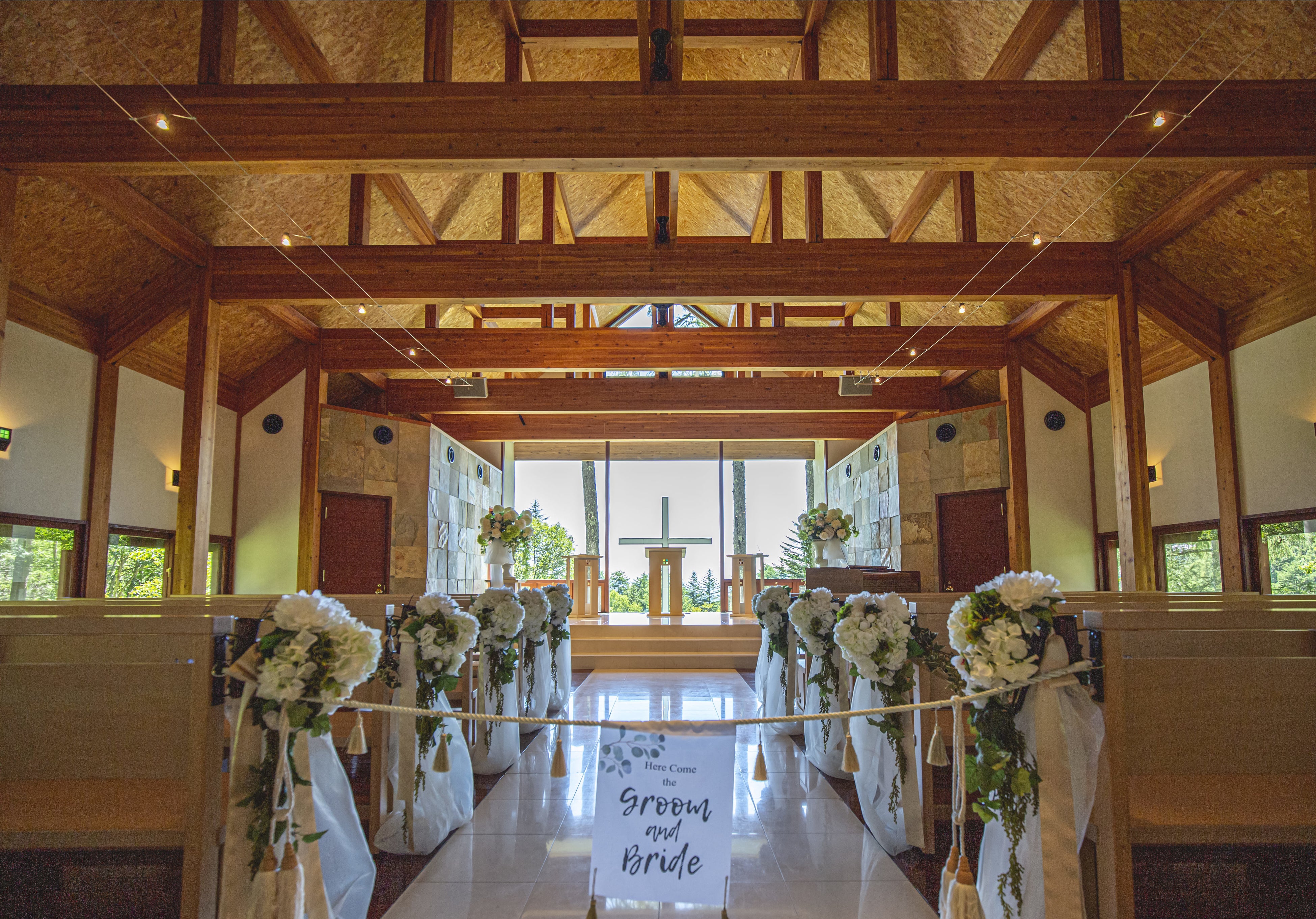 窓から差し込む太陽光と木の温かみを感じるチャペル内観 