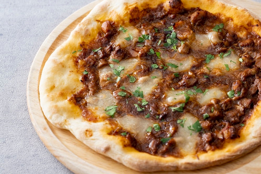 じっくり煮込んだチキンのラグーソースとモッツァレラチーズのピザ