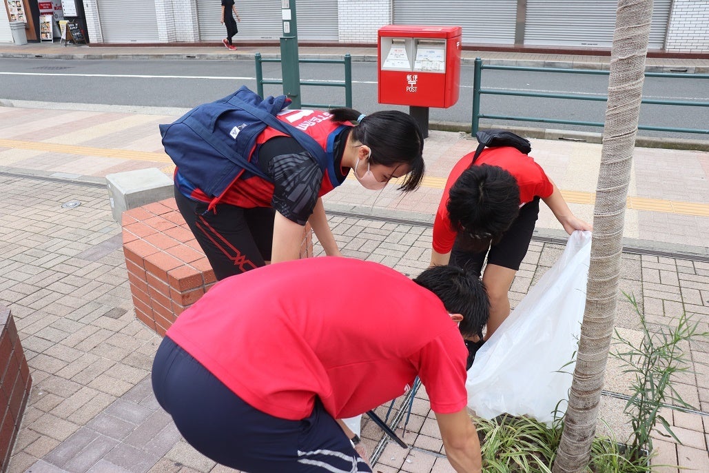 細かいところまで一緒に清掃をする選手とアカデミーの生徒