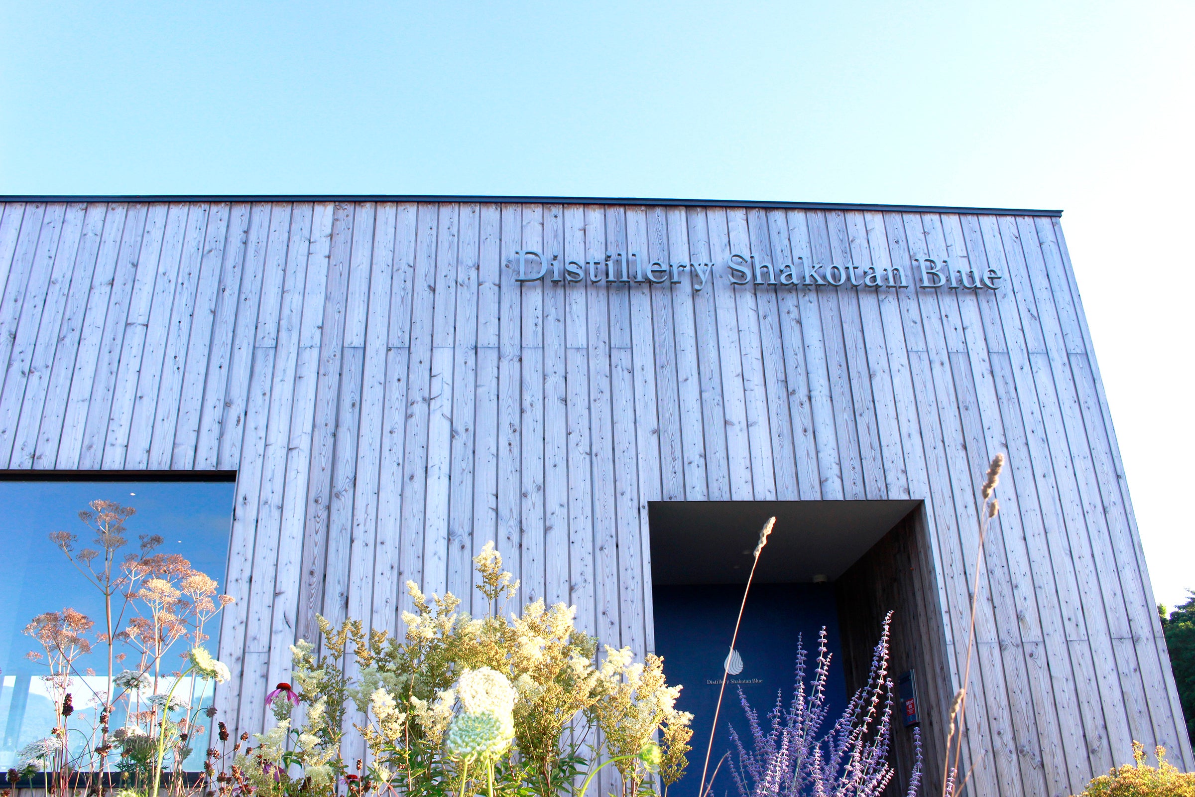 ▲ 崖っぷち温泉・岬の湯に併設する積丹スピリット。ガーデンの隣には羊が放牧されていて、のどかな空気。岬の湯でもクラフトジンを飲むことができます。湯あがりの一杯は最高！