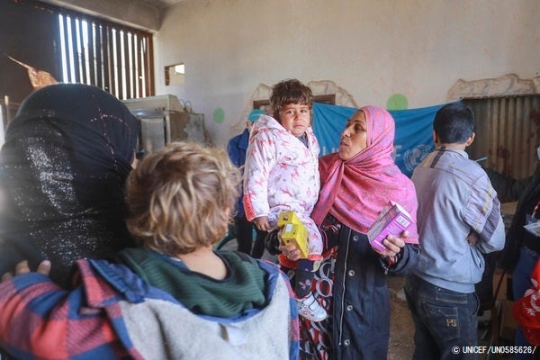ハサカにある避難所のユニセフが支援する移動式クリニックで、栄養不良を防ぐための微量栄養パウダーを受け取った国内避難民の子どもと母親。(シリア、2022年1月28日撮影) © UNICEF_UN0585626_
