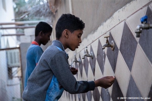 ハドラマウト州で、水道が使えるようになったことを喜ぶ8歳のアイマンくん。ディーゼル燃料を維持する資金が不足するイエメンで、ユニセフは水道システムの太陽光発電利用を支援している。(イエメン、2022年2月28日撮影) © UNICEF_UN0598962_B