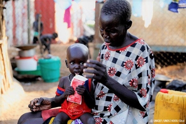 すぐに食べられる栄養治療食(RUTF)を口にする1歳のバラクちゃん。重度の栄養不良で食欲がなかったが、栄養治療を受けて、回復しつつある。(南スーダン、2021年10月撮影) © UNICEF_UN0574000_Chol