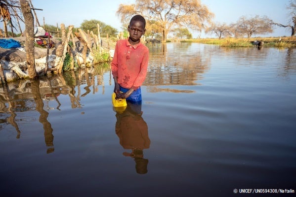 洪水によって溢れた水を汲む13歳のマチエイさん。(南スーダン、2022年1月撮影) © UNICEF_UN0594308_Naftalin