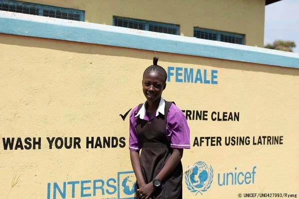 小学校の前に立つジャスミンさん。2020年3月にはCOVID-19によって南スーダンにあるすべての学校が閉鎖していた。(南スーダン、2021年2月撮影) © UNICEF_UN0427993_Ryeng