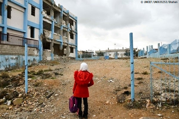紛争によって破壊された学校を眺める14歳のアヤさん。彼女は自宅にいたときに爆撃にあって負傷し、心にも傷を抱えている。（シリア、2022年2月撮影）(c)UNICEF_UN0635253_Shahan