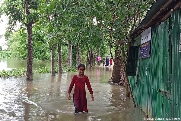 溢れた水の中を歩くエマさん。ユニセフが支援する学校に通っていたが、洪水によって水浸しになってしまった。(バングラデシュ、2022年5月17日撮影)© UNICEF_UN0641537_