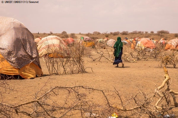 エチオピアの国内避難民キャンプを歩く女性。雨季が3回連続来なかったことにより、アフリカの角地域にある4カ国はここ数十年で最悪の干ばつに苦しんでいる。(エチオピア、2022年4月11日撮影)© UNICEF_UN0631313_Sewunet