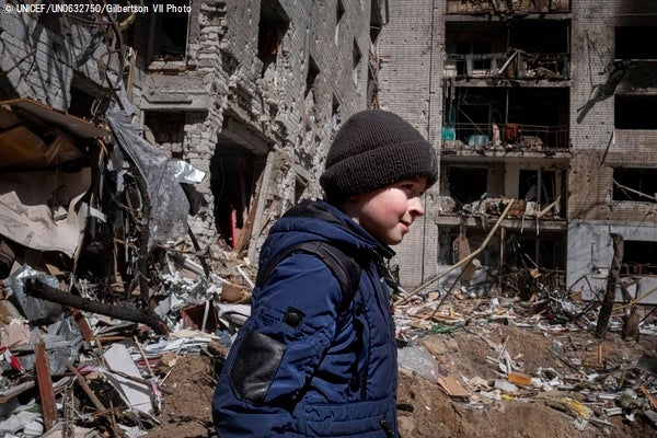 家族と住んでいたアパートの前を歩くボーダンさん(10歳)。度重なる爆撃によって破壊されてしまった。(ウクライナ、2022年4月15日撮影)© UNICEF_UN0632750_Gilbertson VII Photo