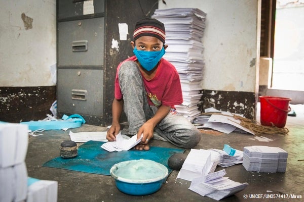 ダッカにある紙のリサイクル店で、紙袋を作る11歳のイムランさん。家庭の経済状況が不安定なため、幼い頃から働いている。(バングラデシュ、2021年5月撮影) © UNICEF_UN0574417_Mawa