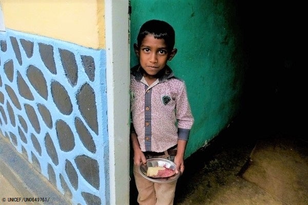 ヌワラエリヤ(Nuwara Eliya)にある自宅で、お昼ご飯を手に持つ男の子。(スリランカ、2022年6月3日撮影) © UNICEF_UN0649761_