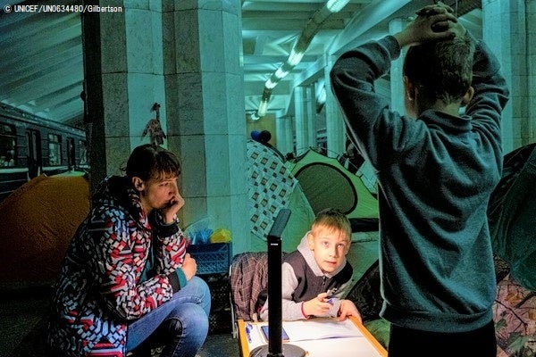 避難したハルキウの地下鉄の中で、母親に見守られながら算数の宿題をする7歳のユリアさん。(ウクライナ、2022年4月撮影) © UNICEF_UN0634480_Gilbertson