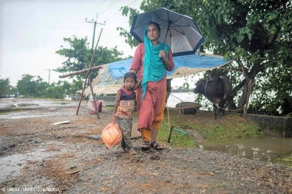 支援物資を受け取り、避難している近くの学校に戻る母親と5歳のセイモンちゃん。「9人家族なので、支援物資は足りない」と母親は話す。© UNICEF_UN0657824_Mukut
