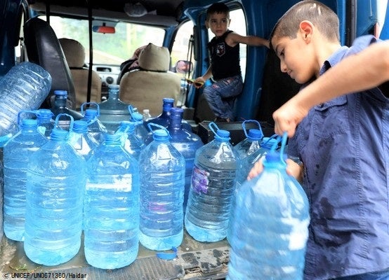 水不足により湧き水をペットボトルに溜めて持ち帰る家族。(レバノン、2021年8月撮影) © UNICEF_UN0671360_Haidar
