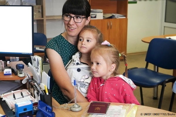 ブチャの社会保護センターの事務所で、ユニセフの現金給付支援を受ける手続きをする家族。(ウクライナ、2022年6月撮影) © UNICEF_UN0677763_Boyko