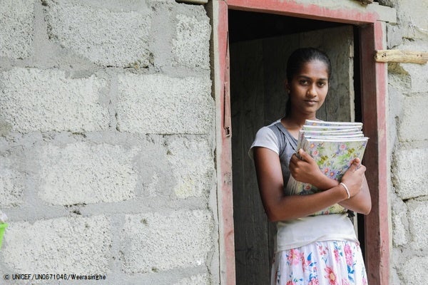 本を持って家の前に立つ15歳のディルクシさん。燃料危機の影響で教師が学校へ来れないため、学校は休校しており、携帯も持っていないためオンライン授業に参加できていない。(スリランカ、2022年7月6日撮影) © UNICEF_UN0671046_Weerasi