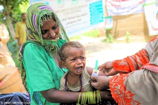 バロチスタン州で洪水の被害を受けた村のユニセフが支援する医療キャンプで、上腕計測メジャーを使い栄養状態を診てもらう1歳のヘラちゃん。(パキスタン、2022年9月7日撮影) © UNICEF_UN0701841_Zaidi