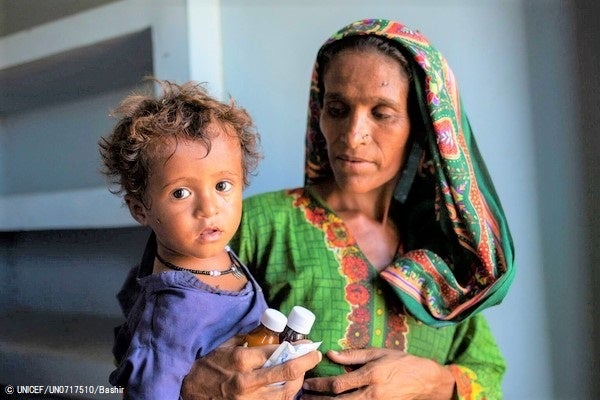 高熱と下痢の症状で訪れた保健ケア施設で、薬を受け取った2歳のナビラちゃん。(パキスタン、2022年9月26日撮影) © UNICEF_UN0717510_Bashir