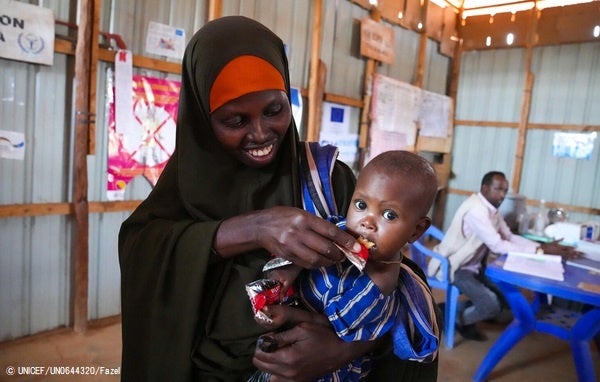 ドロー保健センターで、すぐに食べられる栄養治療食(RUTF)を母親に食べさせてもらう生後10カ月のウバちゃん。(ソマリア、2022年5月撮影) © UNICEF_UN0644320_Fazel