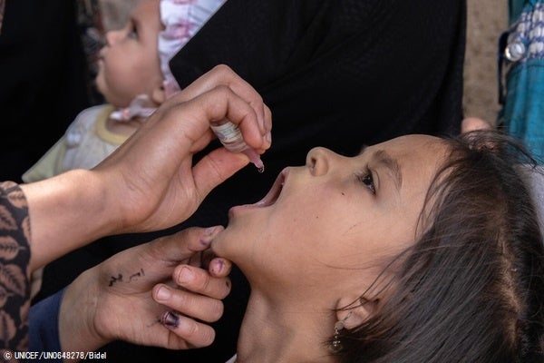 ヘラートの自宅まで、経口ポリオワクチンの投与を受ける女の子。(アフガニスタン、2022年5月撮影) © UNICEF_UN0648278_Bidel