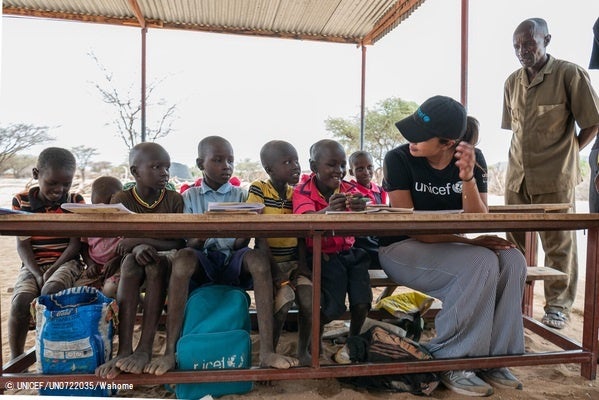 小学4年生の生徒たちと一緒に座るプリヤンカー・チョープラー・ジョナス親善大使。この学校は、ユニセフが復旧した太陽光発電システムにより、花壇やキッチン、保健室に水を供給している。(ケニア、2022年10月17日撮影) © UNICEF_UN0722035_W