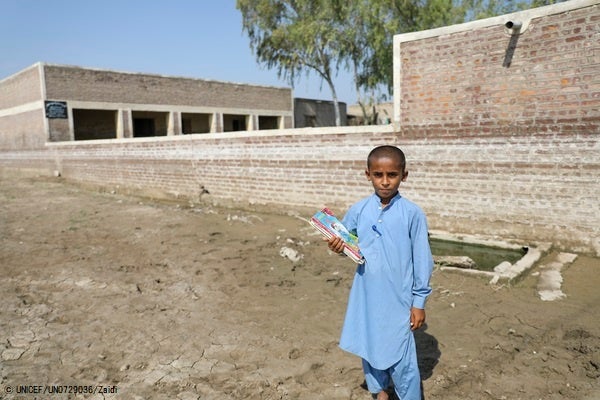 洪水の被害を受けた公立小学校の前に立つ9歳のムハンマドくん。(パキスタン、2022年10月31日撮影) © UNICEF_UN0729036_Zaidi