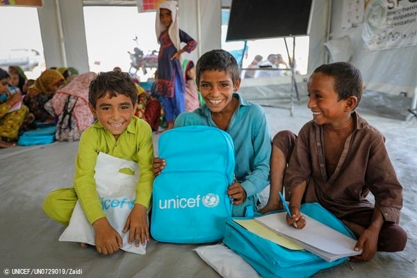 シンド州の国内避難民キャンプ内に、ユニセフが被災した子どもたちのために設置した一時学習センターで、授業を受ける6歳のファリドくん(左)、8歳のカシーフくん(中央)、7歳のムハンマドくん(右)。(パキスタン、2022年10月31日撮影) © UNICEF_U