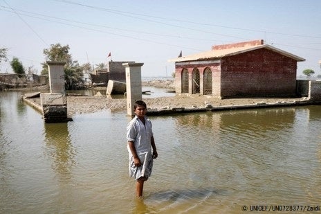 シンド州の浸水した学校の前に立つ8歳のシャヒドくん。一時は屋根まで浸水し、水位が下がってもまだ学校は再開できていない。(パキスタン、2022年10月30日撮影) © UNICEF_UN0728377_Zaidi
