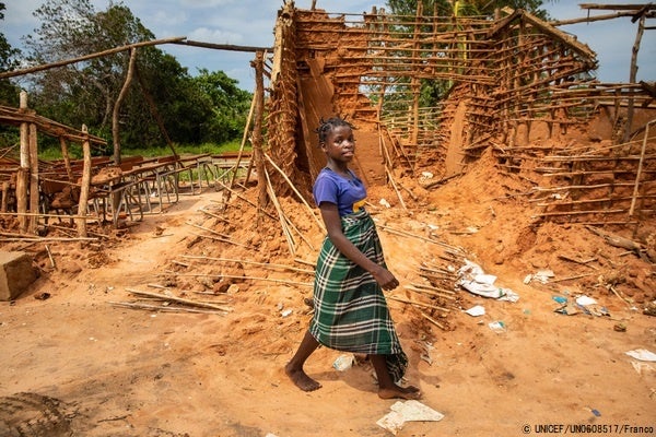 ナンプラ州で、サイクロンにより破壊された学校の前を通る13歳のマリアーノさん。(モザインビーク、2022年3月撮影) © UNICEF_UN0608517_Franco