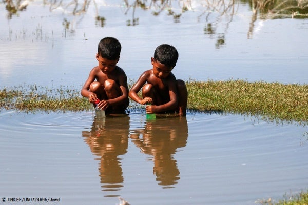 南部にあるベンガル湾で、サイクロンの影響により浸水した場所から、生活に使える物を探す子どもたち。(バングラデシュ、2022年10月25日撮影) © UNICEF_UN0724665_Jewel