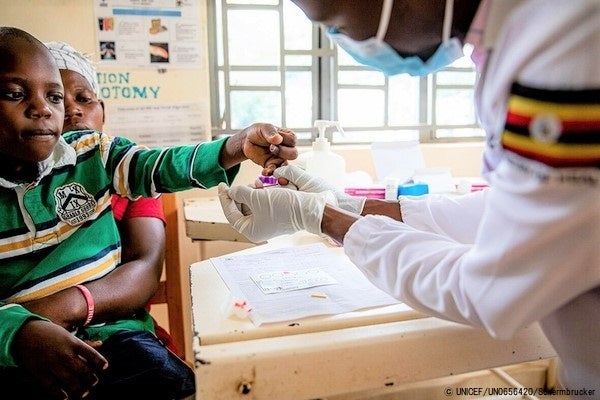 HIVに感染し、ウイルス量の検査を受ける9歳のロナルドさんと母親。体調を崩していたが、投薬治療のおかげで容態は良くなりつつある。(ウガンダ、2022年4月撮影) © UNICEF_UN0656420_Schermbrucker