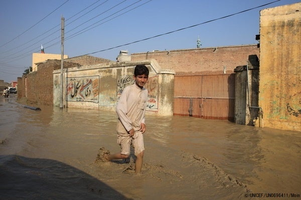 カイバル・パクトゥンクワ州で、大洪水の影響により浸水した道を歩く子ども。(パキスタン、2022年8月撮影) © UNICEF_UN0696411_Moin