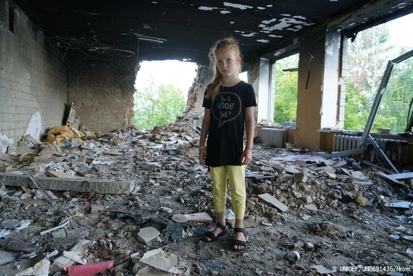 2～3月の間で14回もの砲撃やロケット弾の攻撃を受け、破壊された学校の瓦礫の中に立つ8歳のアーニャさん。(ウクライナ、2022年7月撮影) © UNICEF_UN0691435_Hrom