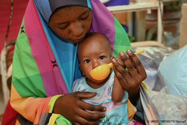 タウア州で栄養補助食を母親に食べさせてもらう、栄養不良で生後8カ月のフォージアちゃん。(ニジェール、2022年8月撮影) © UNICEF_UN0688716_Dejongh