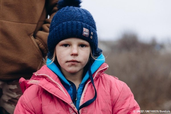 ドネツク州リマンの検問所で、水や食べ物などの支援物資を受け取った6歳のナディヤさん。(ウクライナ、2022年11月27日撮影) © UNICEF_UN0749029_Bundzylo