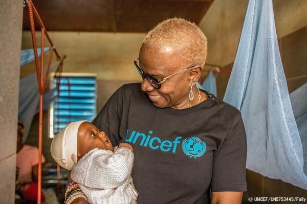 栄養治療センターで、栄養不良の治療を受ける子どもを抱くユニセフ親善大使のアンジェリーク・キジョー氏。(ベナン、2022年12月15日撮影) © UNICEF_UN0753445_Folly