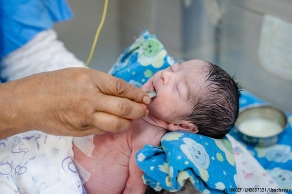 カトマンズの産婦人科病院の新生児集中治療室(NICU)で、ミルクを飲む生まれたての赤ちゃん。(ネパール、2022年8月撮影) © UNICEF_UN0687321_Upadhayay