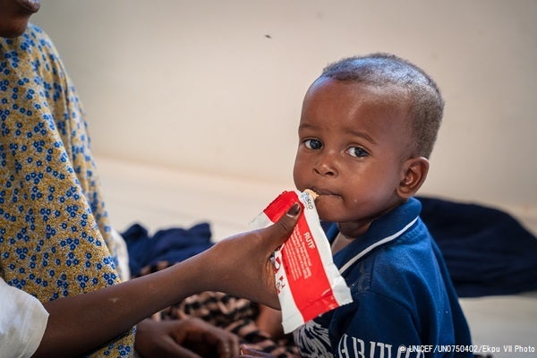 プントランドの病院にある急性栄養不良を治療するセンターで、すぐに食べられる栄養治療食(RUTF)を母親に食べさせてもらう1歳のアドブラちゃん。(ソマリア、2022年10月撮影) © UNICEF_UN0750402_Ekpu VII Photo