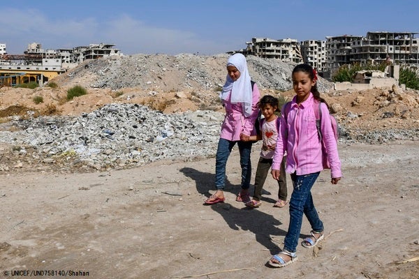 ダマスカスの農村部で、瓦礫の横を通って学校に向かう子どもたち。(シリア、2022年10月撮影) © UNICEF_UN0758140_Shahan