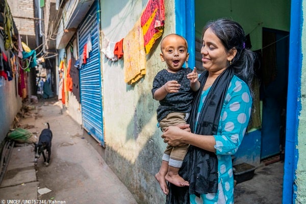 ダッカのスラム街で暮らす1歳のハスナットちゃんと母親。近くにユニセフが支援する診療所ができ、早朝から夜まで、質の高い保健医療を手頃な費用で受けることができる。(バングラデシュ、2022年12月撮影) © UNICEF_UN0757346_Rahman