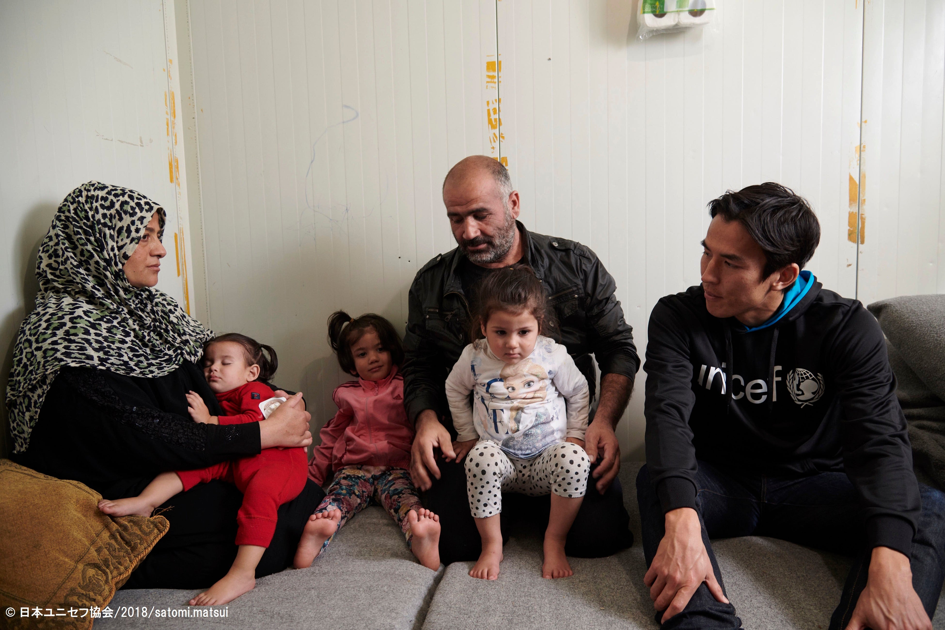 2018年にギリシャのエスカラマンガス難民キャンプを訪れた時、タレックさんの両親から、シリアからギリシャに逃れて来た時の様子を聞く長谷部大使。(ギリシャ、2018年11月撮影)© 日本ユニセフ協会_2018_satomi.matsui