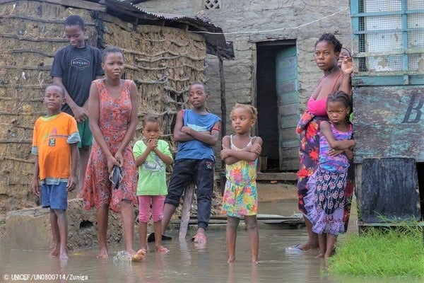 サイクロン「フレディ」により浸水した、ケリマネ近郊の自宅前に立つ家族。母親は、雨による寒さと空腹を訴える子どもたちを避難所へ連れて行くか考えている。(モザンビーク、2023年3月11日撮影) © UNICEF_UN0800714_Zuniga